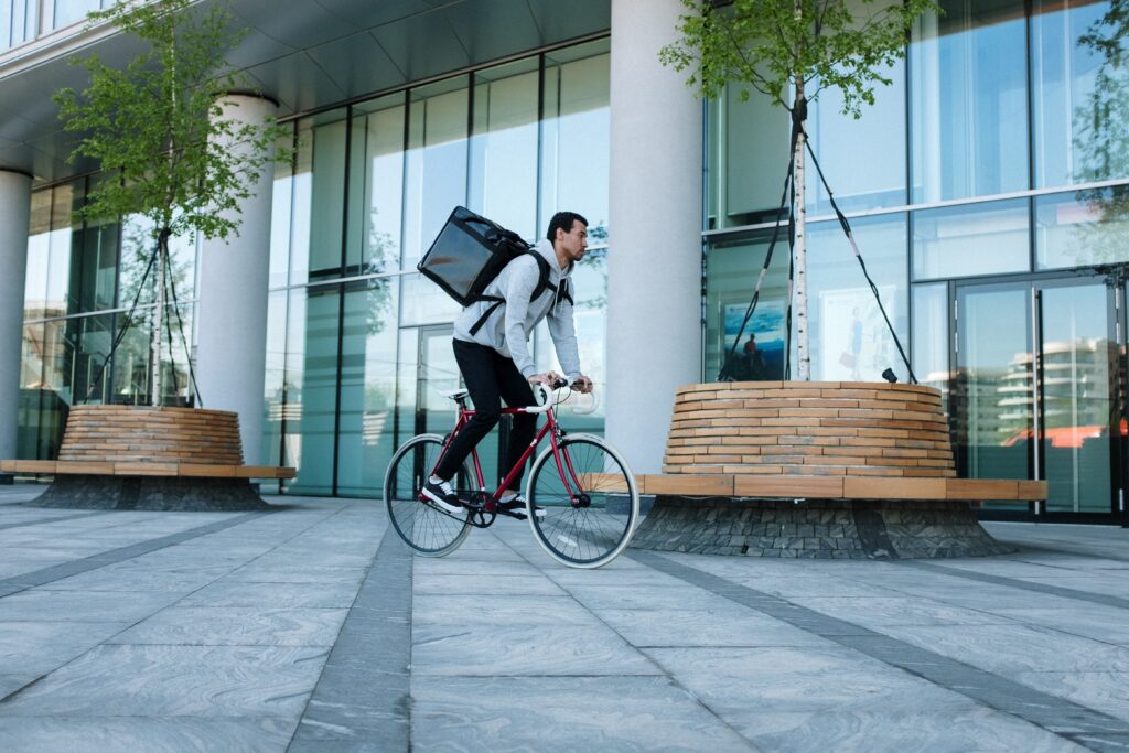 um homem andando de bicicleta com uma mochila nas costas