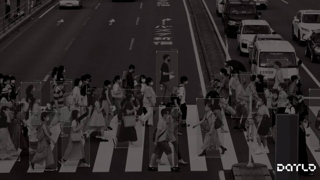 uma foto em preto e branco de pessoas atravessando a rua