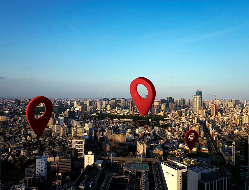 Imagem colorida, composta por uma cidade grande, onde em pontos estratégicos tem markers demarcando algo. Essa imagem está sendo utilizada para representar o marketing de geolocalização.